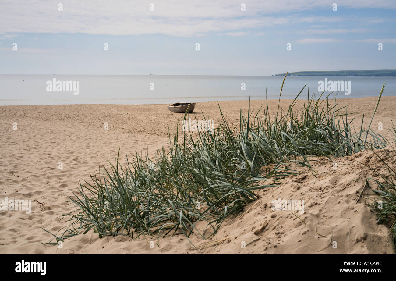Vecchia barca grigio sulla spiaggia di barene Foto Stock