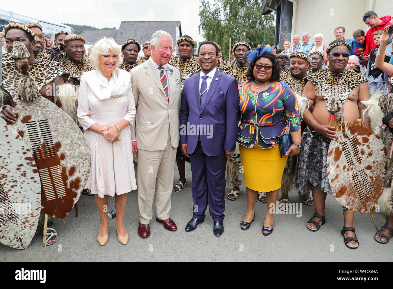 Il Principe di Galles e la duchessa di Cornovaglia soddisfare la buona volontà re e regina Pumi della nazione Zulu durante il centesimo Royal Welsh Show presso il Royal Welsh Showground, Llanelwedd, Builth Wells. Foto Stock