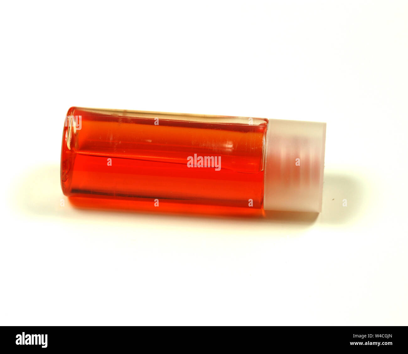 Bottiglia con liquido arancione isolato su bianco Foto Stock