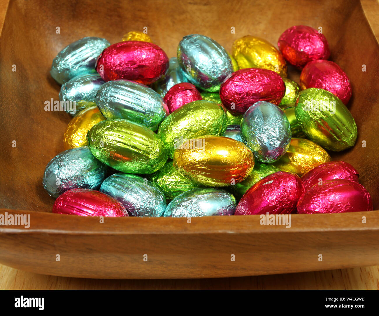 Uova di Pasqua nel recipiente di legno - dolce colorata presente Foto Stock