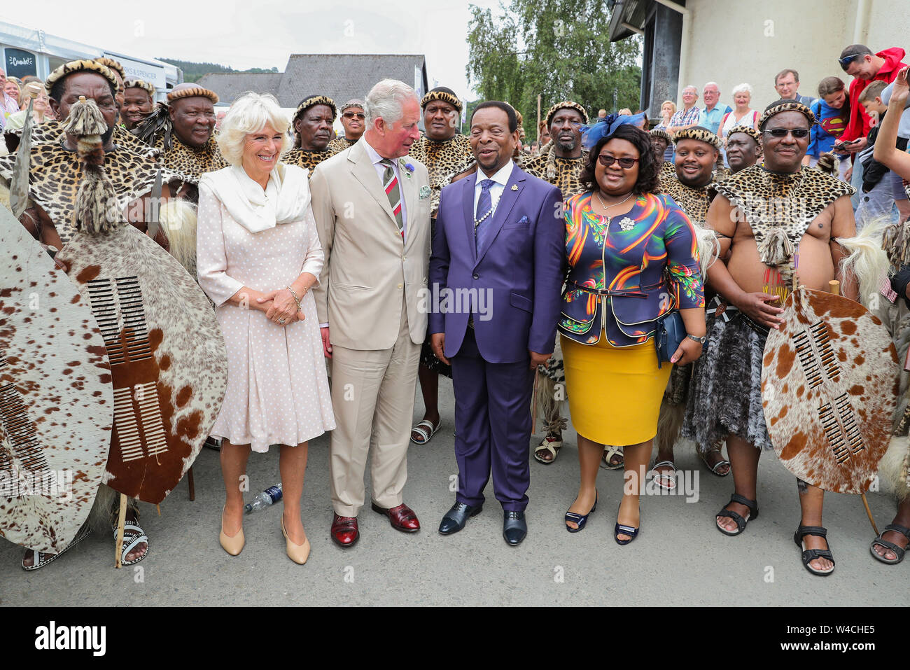 Il Principe di Galles e la duchessa di Cornovaglia soddisfare la buona volontà re e regina Pumi della nazione Zulu durante il centesimo Royal Welsh Show presso il Royal Welsh Showground, Llanelwedd, Builth Wells. Foto Stock