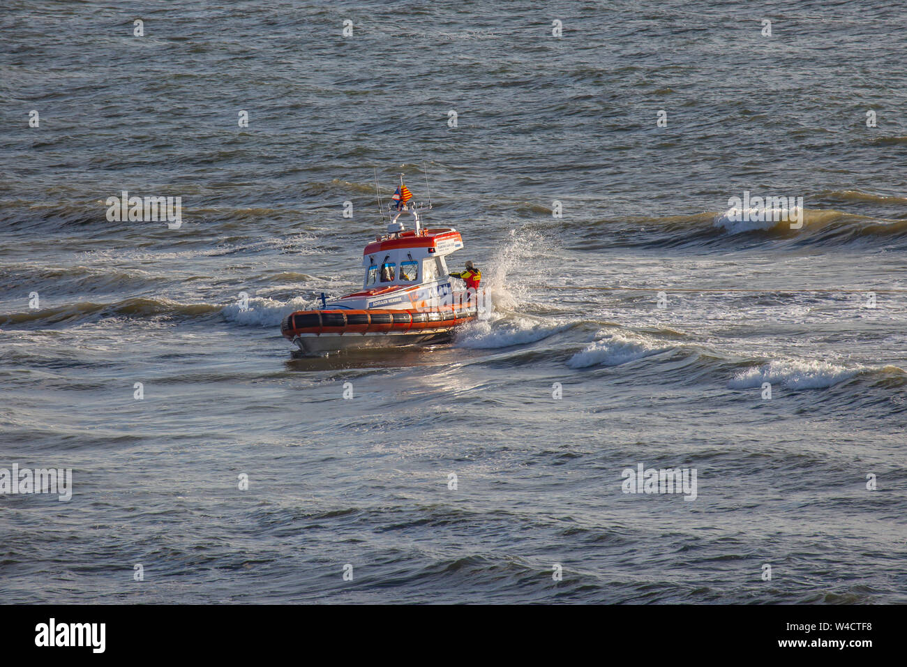 Egmond aan Zee, Paesi Bassi - 22 Luglio 2019: membri della guardia costiera olandese su una scialuppa di salvataggio in mare del nord durante un trapano di salvataggio Foto Stock