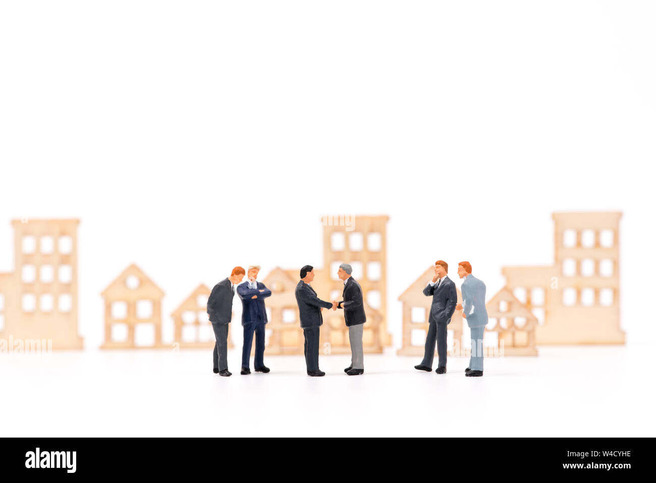 Imprenditore in miniatura che trattano proprietà e agitando la mano Foto Stock