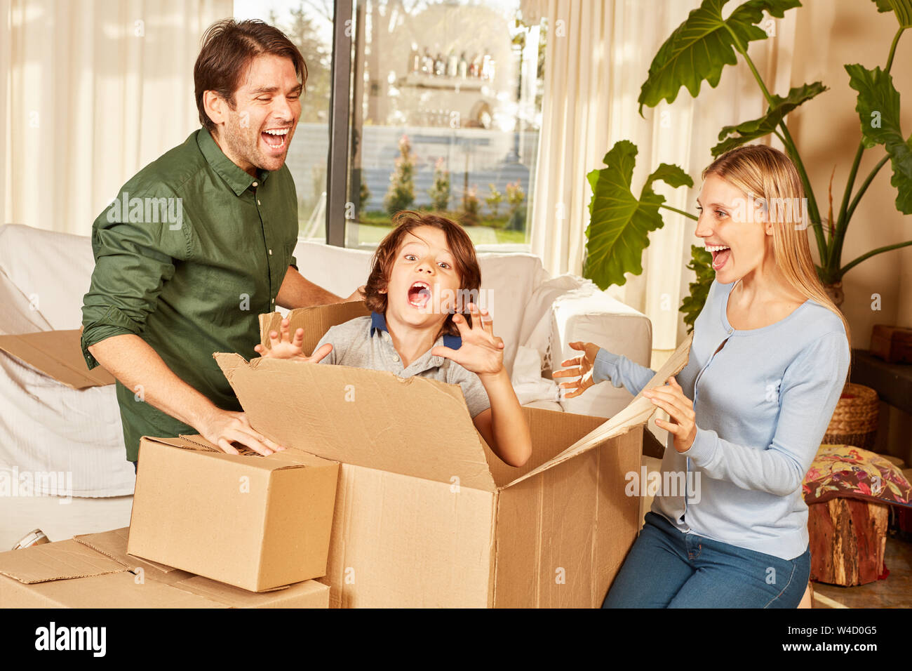 Ragazzo con carrello in movimento la paura dei suoi genitori nella nuova casa in pelle e cercano il gioco Foto Stock