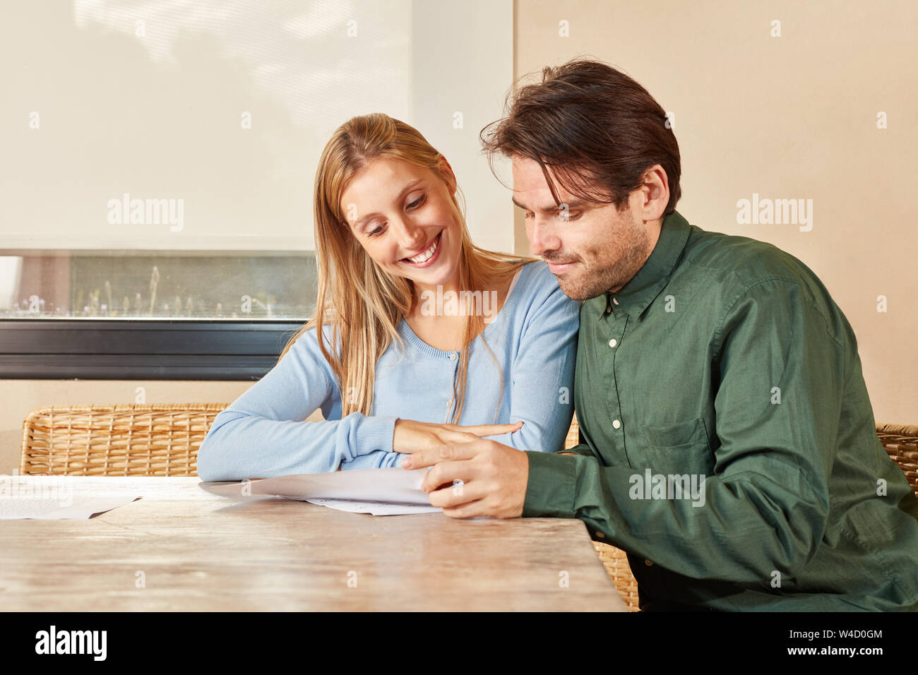 Coppia giovane leggere insieme il ritorno fiscale o di un contratto di credito Foto Stock