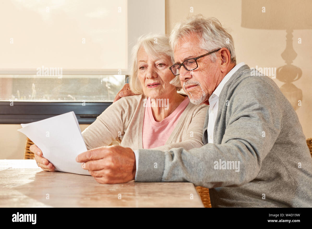 Coppia senior insieme la lettura di un piano di pensionamento o un contratto assicurativo Foto Stock