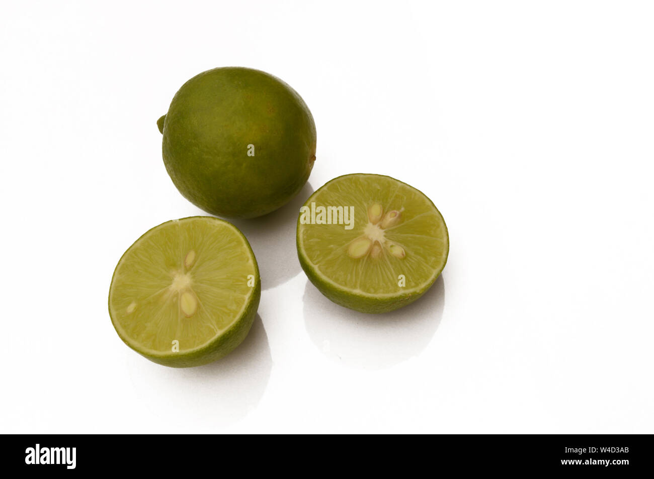Fresco intero organico e fette di limes isolati su sfondo bianco. Foto Stock