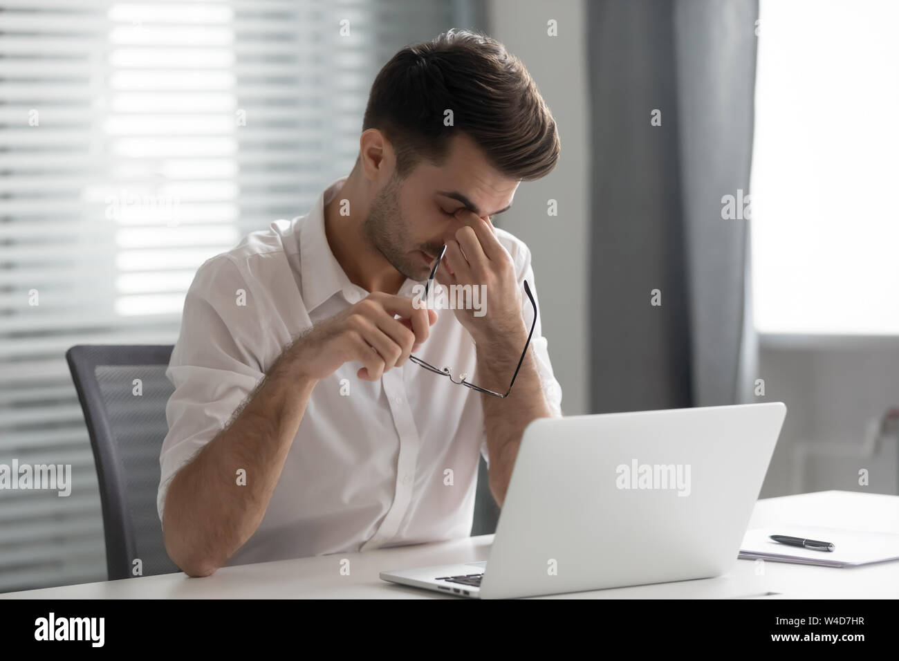 Oberati di lavoro ha sottolineato il business man holding massaggio occhiali da ponte per il naso Foto Stock