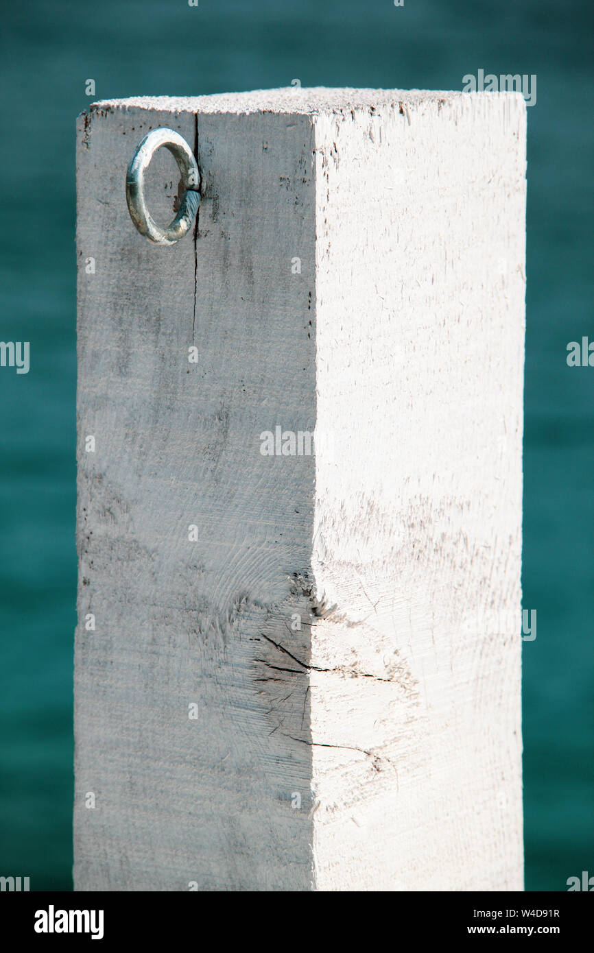 Bianco rustico in legno post dal mare con ganci in metallo Foto Stock