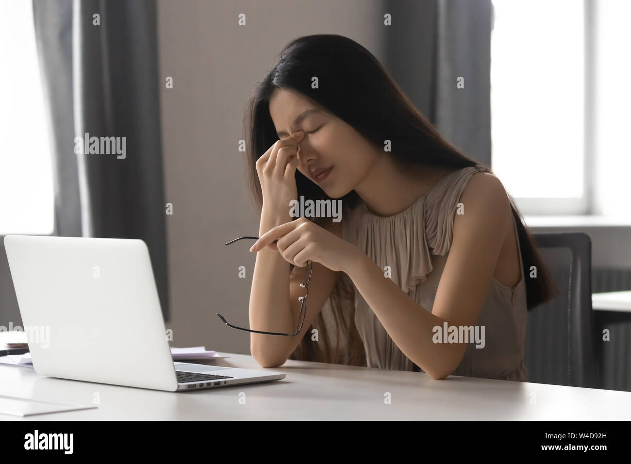 Oberati di lavoro ha sottolineato asian business woman holding bicchieri sensazione di affaticamento della vista Foto Stock