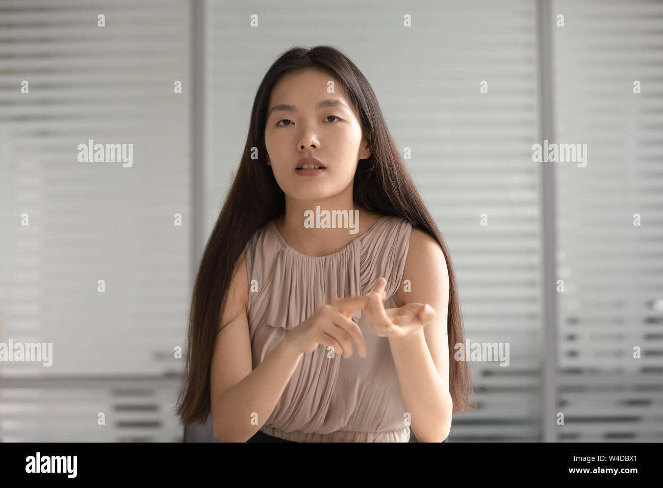 Grave asian professional imprenditrice guardare parlare con telecamera in ufficio Foto Stock