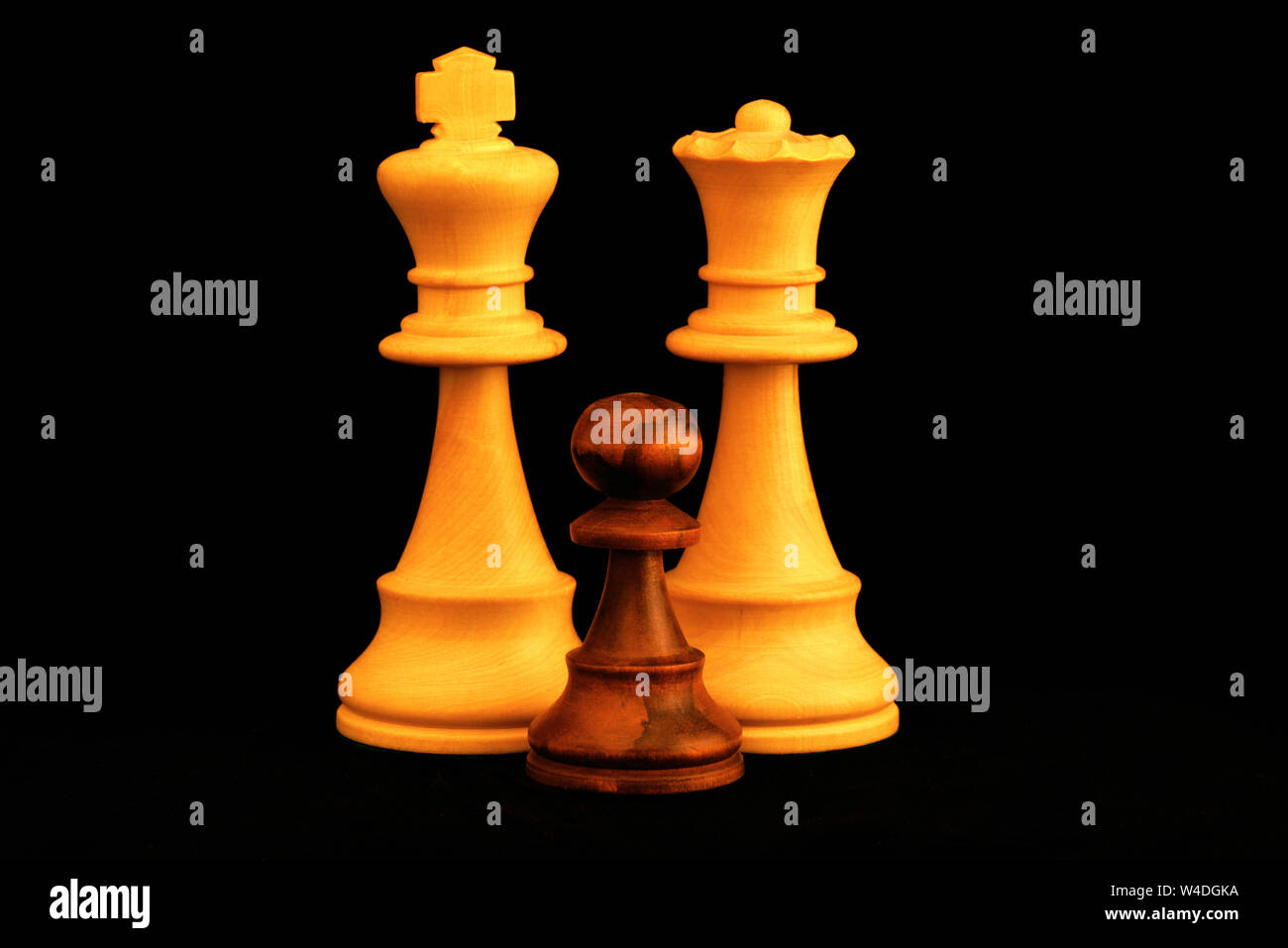 Re bianco e la regina con il pedone nero famiglia come interracial adozione del concetto. Standard del gioco degli scacchi pezzi di legno su sfondo nero Foto Stock
