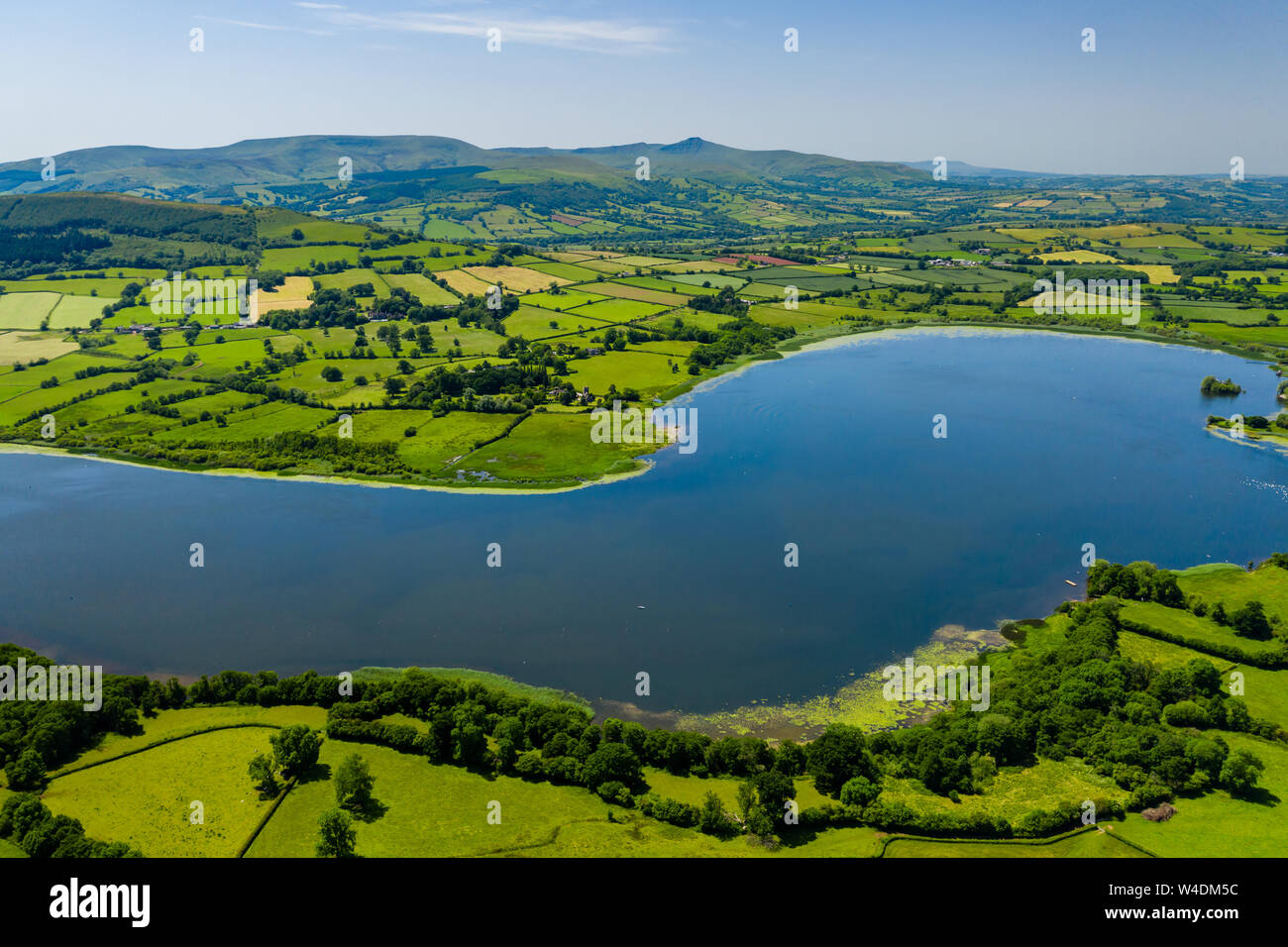 Vista aerea di un lago circondato da verdi, rolling farmland (lago Llangorse, Galles) Foto Stock
