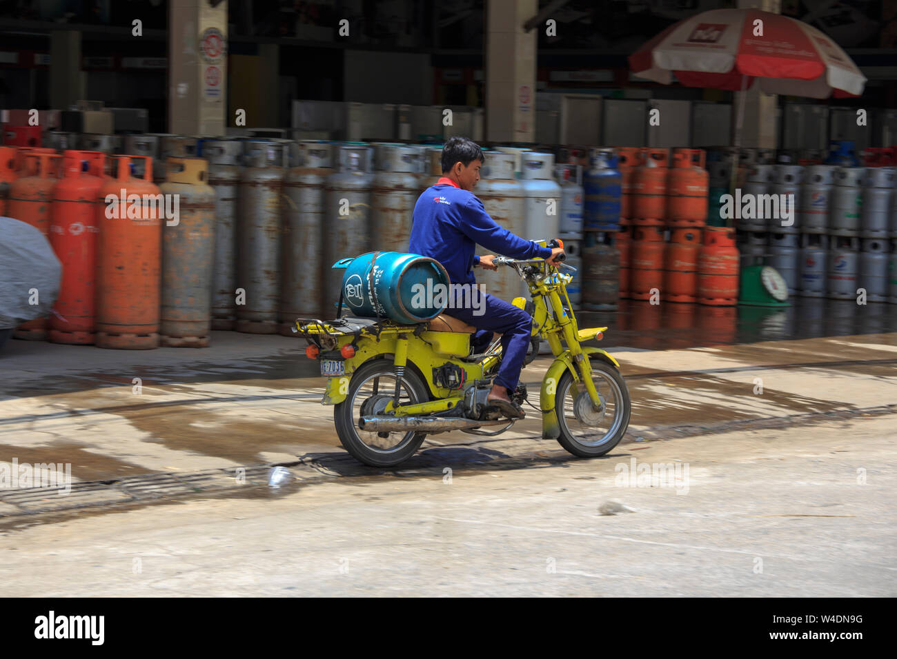 Phnom Phen, Cambogia - Aprile 25, 2014: Uomini non identificati è il trasporto di gas cilindro in motocicli Foto Stock