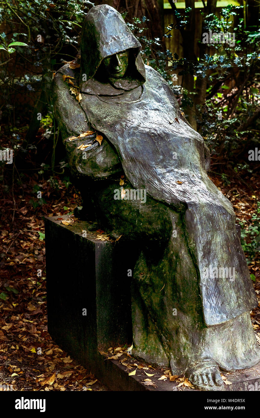 Una scultura di un uomo che indossa un mantello e il cofano sul display in un parco della scultura Foto Stock