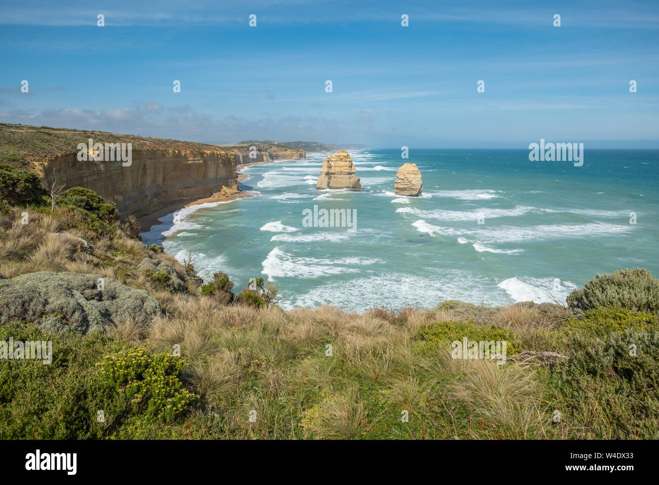 Guardando verso est lungo l'Australia meridionale della costa con il mare turchese e le onde di battitura: i dodici Apostoli, Great Ocean Road, Victoria Foto Stock