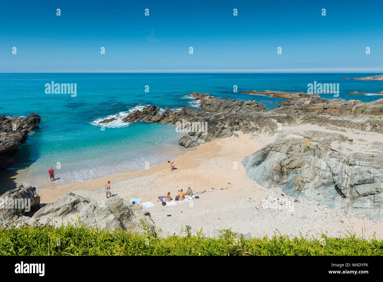 Il bellissimo mare turchese intorno alla spiaggia appartata a poco Fistral a Newquay in Cornovaglia. Foto Stock