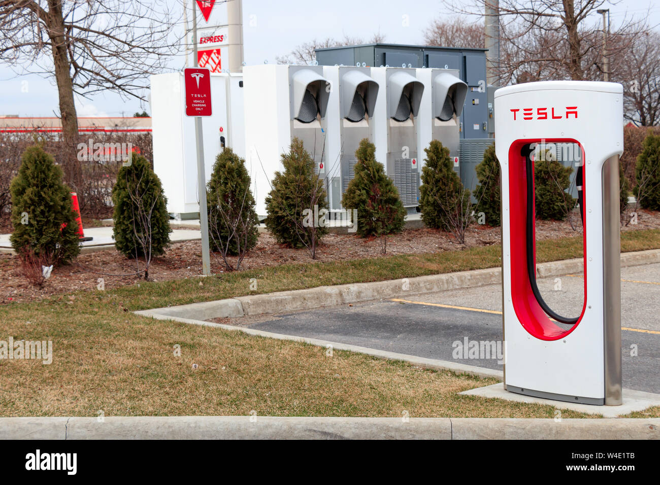 Tesla Supercharger stallo con potenza di Tesla/tecnologia di carica in background. Foto Stock