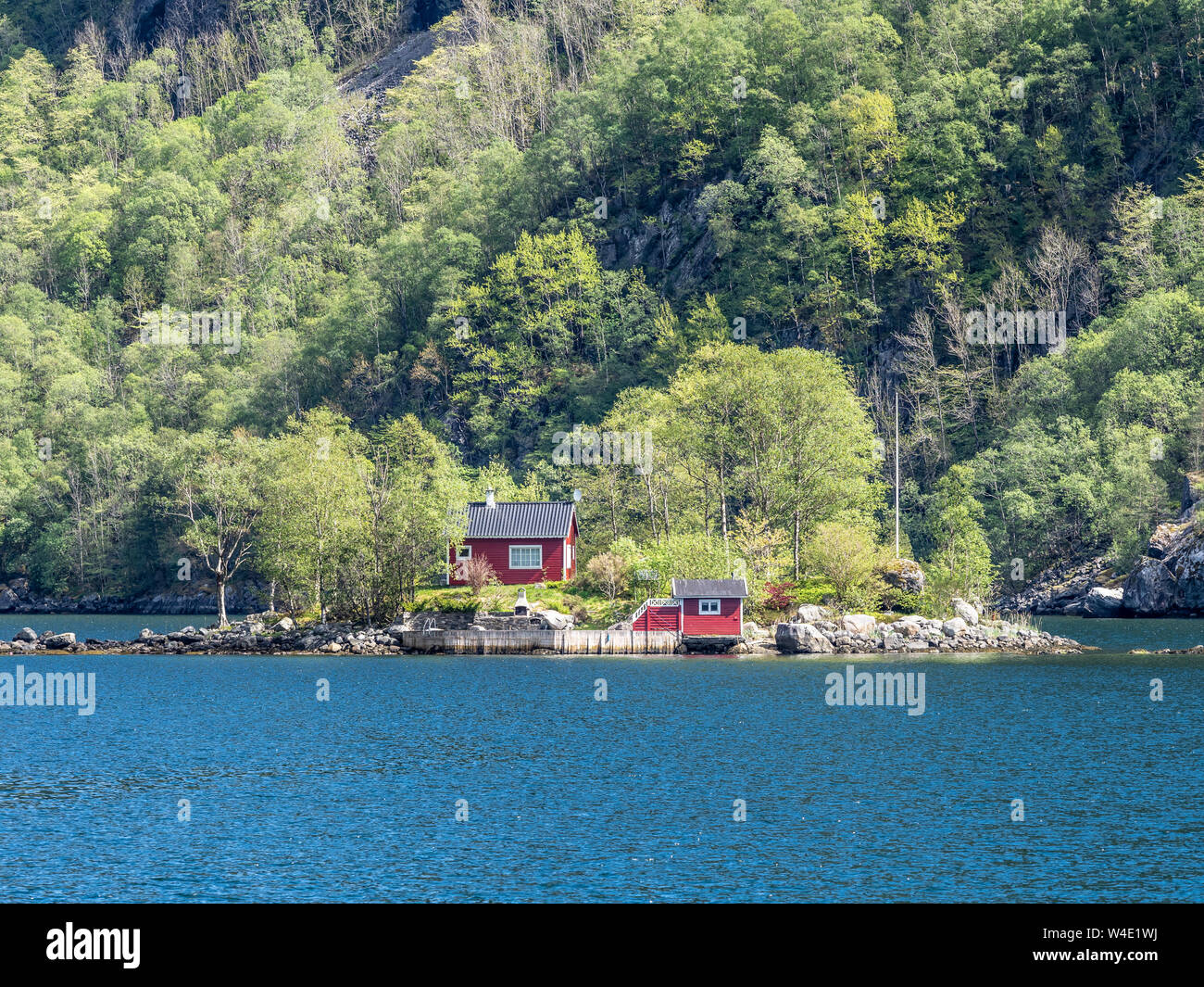 Rosso tipico cottage norvegese su una piccola isola nel fiordo, Lovrafjord, Norvegia Foto Stock