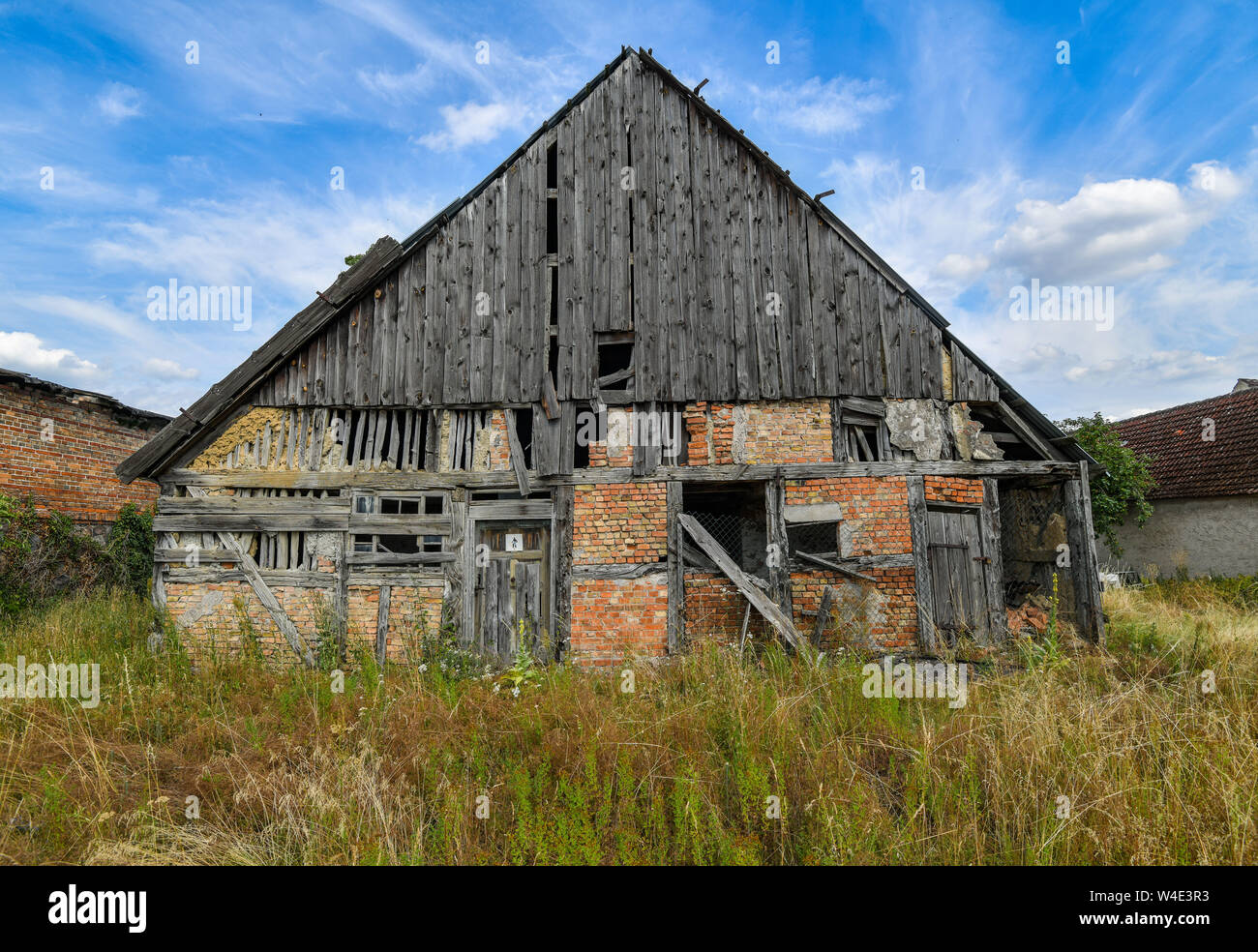 Altranft, Germania. Il 20 luglio, 2019. Un timpano in legno della facciata esterna con mezza-quadro con travi di legno e muro di mattoni del corridoio centrale house a partire dall'anno 1698, che sorge a vuoto per circa 50 anni. Kiri Westphal e Matthias Ciupa salvare case antiche, alla cui vista tutti gli altri sarebbero resignedly declino. Ora che osano avventurarsi per una storica del medio-casa piano in Altranft, la più antica del Oderbruch. La contea ha venduto loro il memoriale che è stato lasciato vuoto per 50 anni. Credito: Patrick Pleul/dpa-Zentralbild/ZB/dpa/Alamy Live News Foto Stock