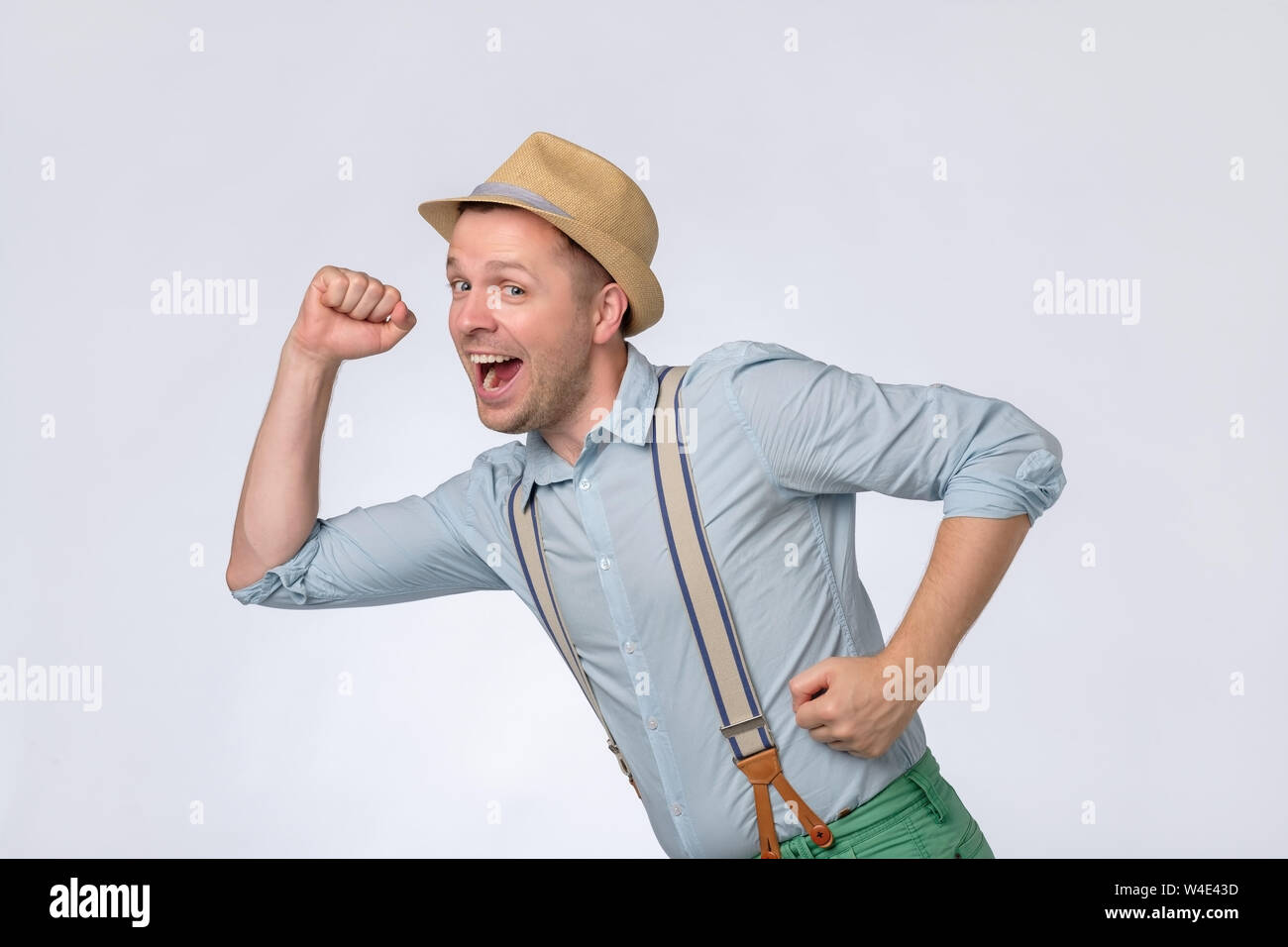 Attraente giovane uomo in estate hat corre veloce. Egli ha ricevuto una grande notizia. Foto Stock