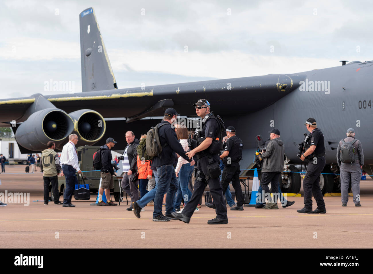 Armati di pattuglia di polizia presso il Royal International Air Tattoo airshow, RAF Fairford, Cotswolds, UK. Boeing B Stratofortress bombardiere nucleare piano Foto Stock