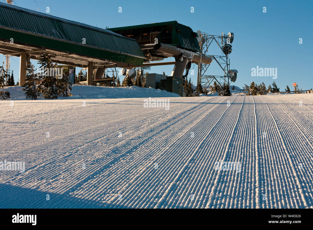 La cima del quad ascensore, i piatti di comunicazione sullo sfondo, la neve curata pronti per i primi sciatori della giornata prendono oggi la loro prima corsa. Foto Stock