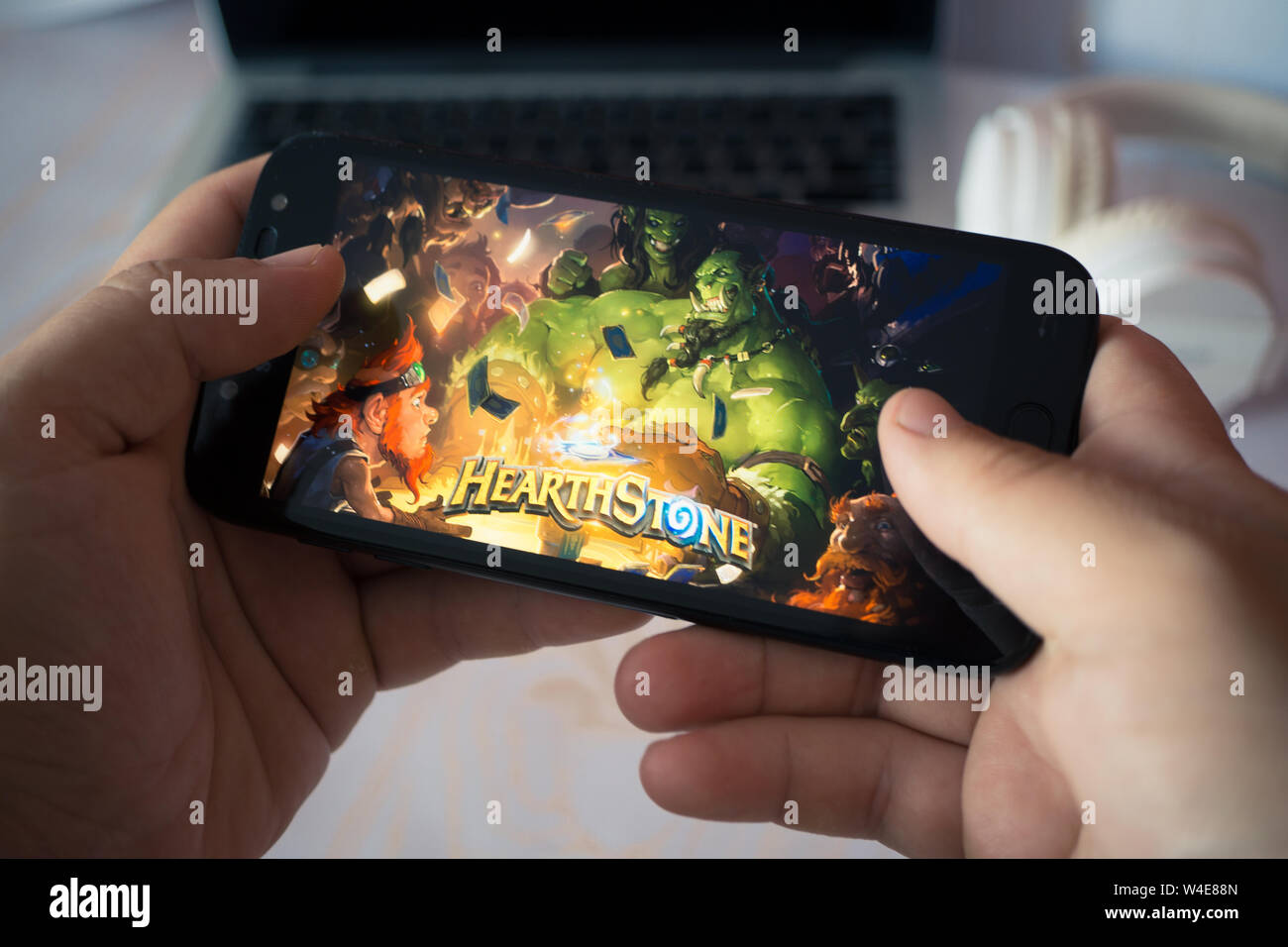 Nizhyn, Ucraina/Luglio-16-2019: mani tenendo lo smartphone e riproduzione Hearthstone. Android il concetto di gioco. Foto Stock