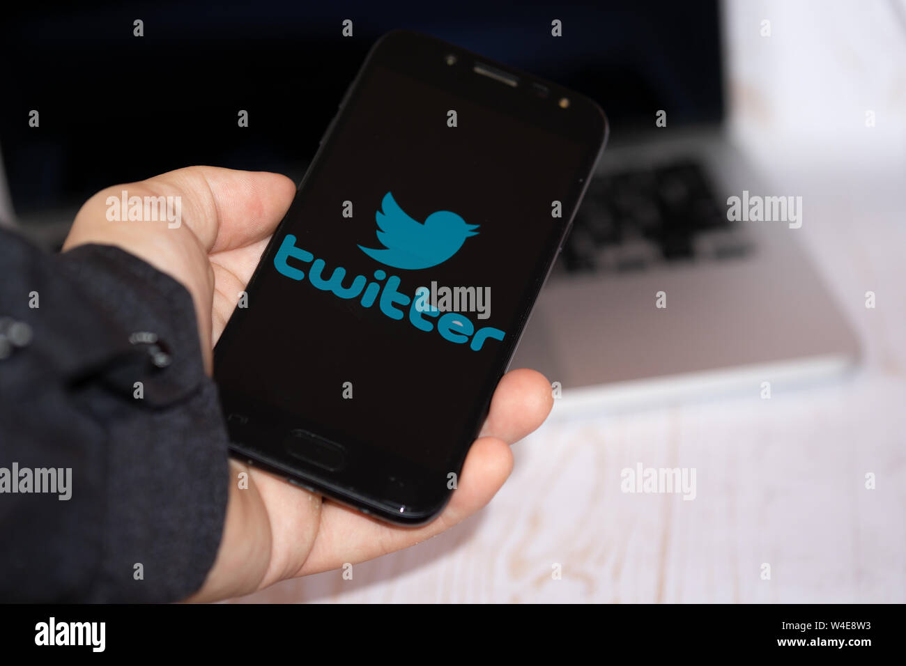 Nizhyn, Ucraina/Luglio-16-2019: giovane rappresentante Uomo in camicia nera tenere lo smartphone e utilizzare Twitter app. Social media e concetto corporativo. app. Foto Stock