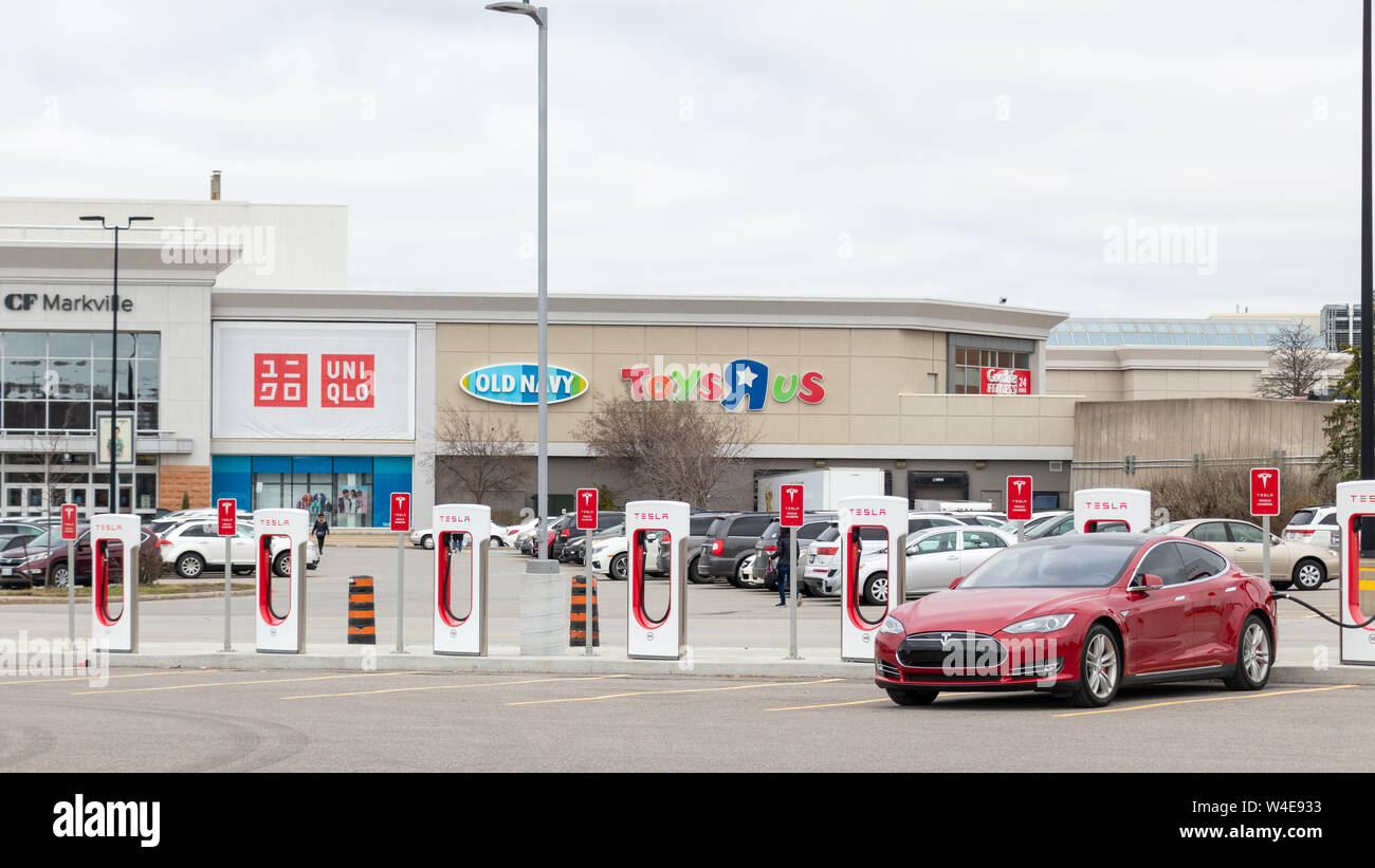 Rosso Modello Tesla S sovralimentazione ai Tesla Supercharger davanti CF Markham Shopping Center. Foto Stock