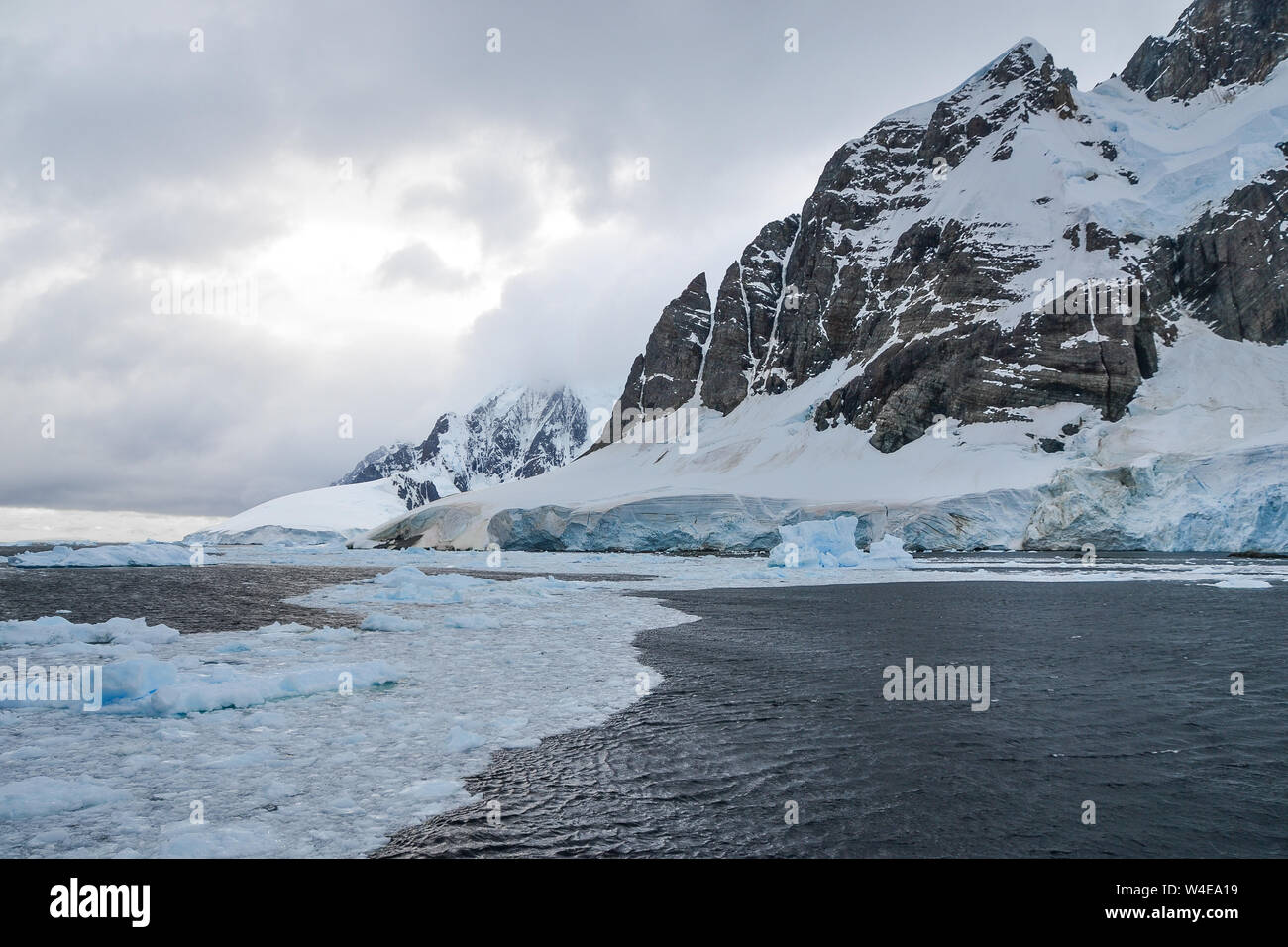 Fusione del ghiaccio nella parte anteriore del ghiacciaio antartico e montagna Foto Stock