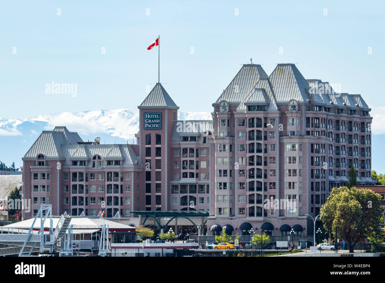 Hotel Grand Pacific in una giornata di sole a Victoria, BC, con montagne coperte di neve sullo sfondo. Foto Stock