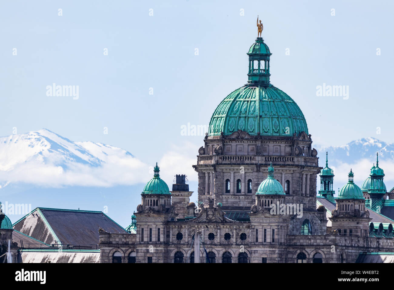 Assemblea legislativa della Columbia Britannica edificio in una giornata di sole a Victoria, BC con montagne coperte di neve sullo sfondo. Foto Stock