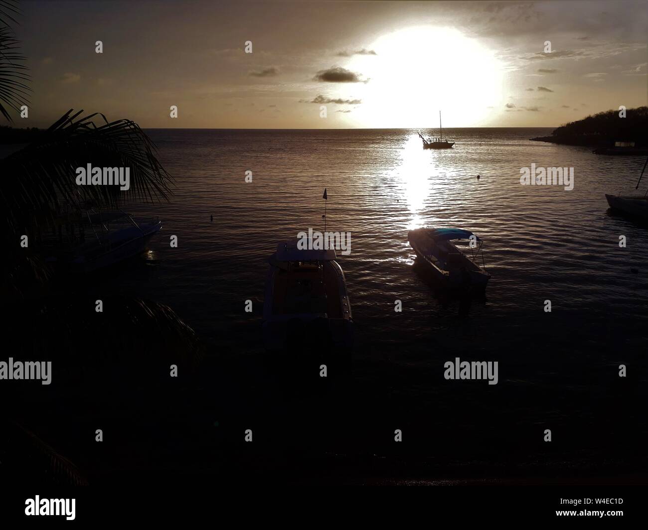 Sunset beach con barche, oceano mare, palme, Roatan Island, Honduras, America Centrale e dei Caraibi. Foto Stock