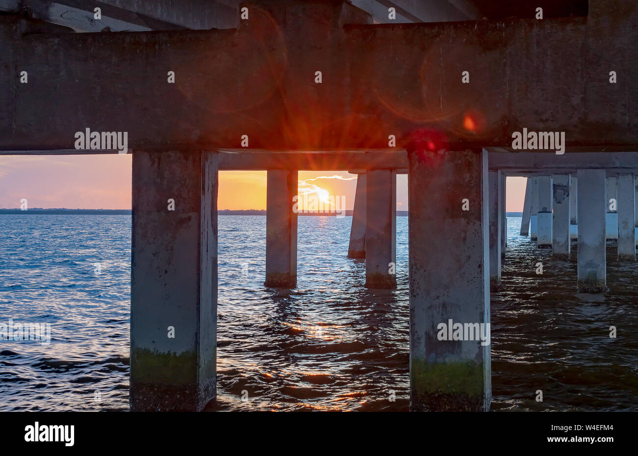 Vista dell'alba sotto il ponte sopra l'acqua Foto Stock