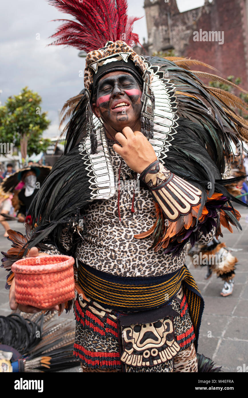 Aztec ballerino (dopo street esecuzione) per chiedere contributi, mentre si allenta la sua acconciatura. Zocalo, Città del Messico, CDMX, Messico. Giu 2019 Foto Stock