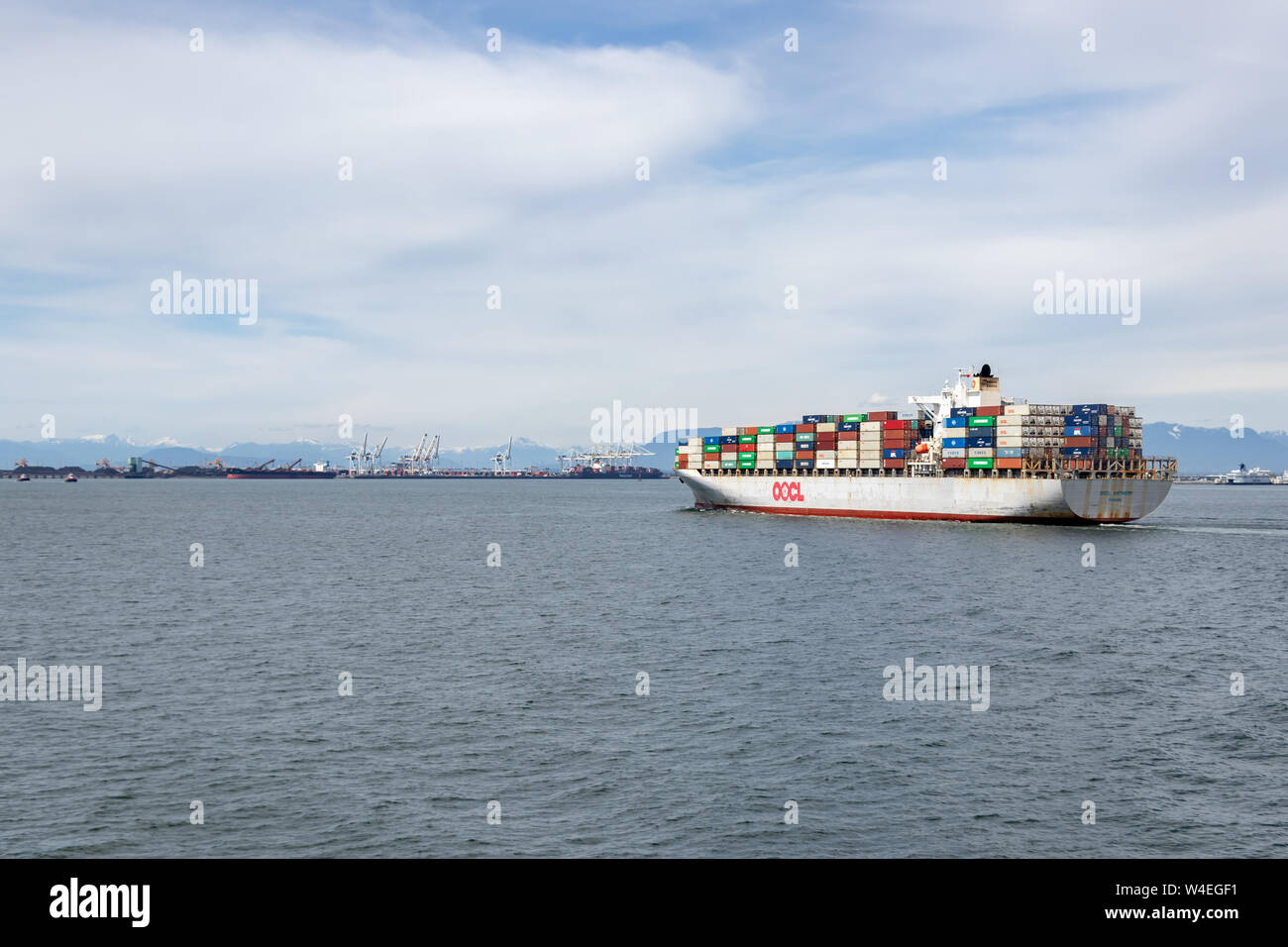 OOCL Anversa contenitore tirando della nave nel porto di Vancouver da Kaohsiung, Taiwan. Foto Stock