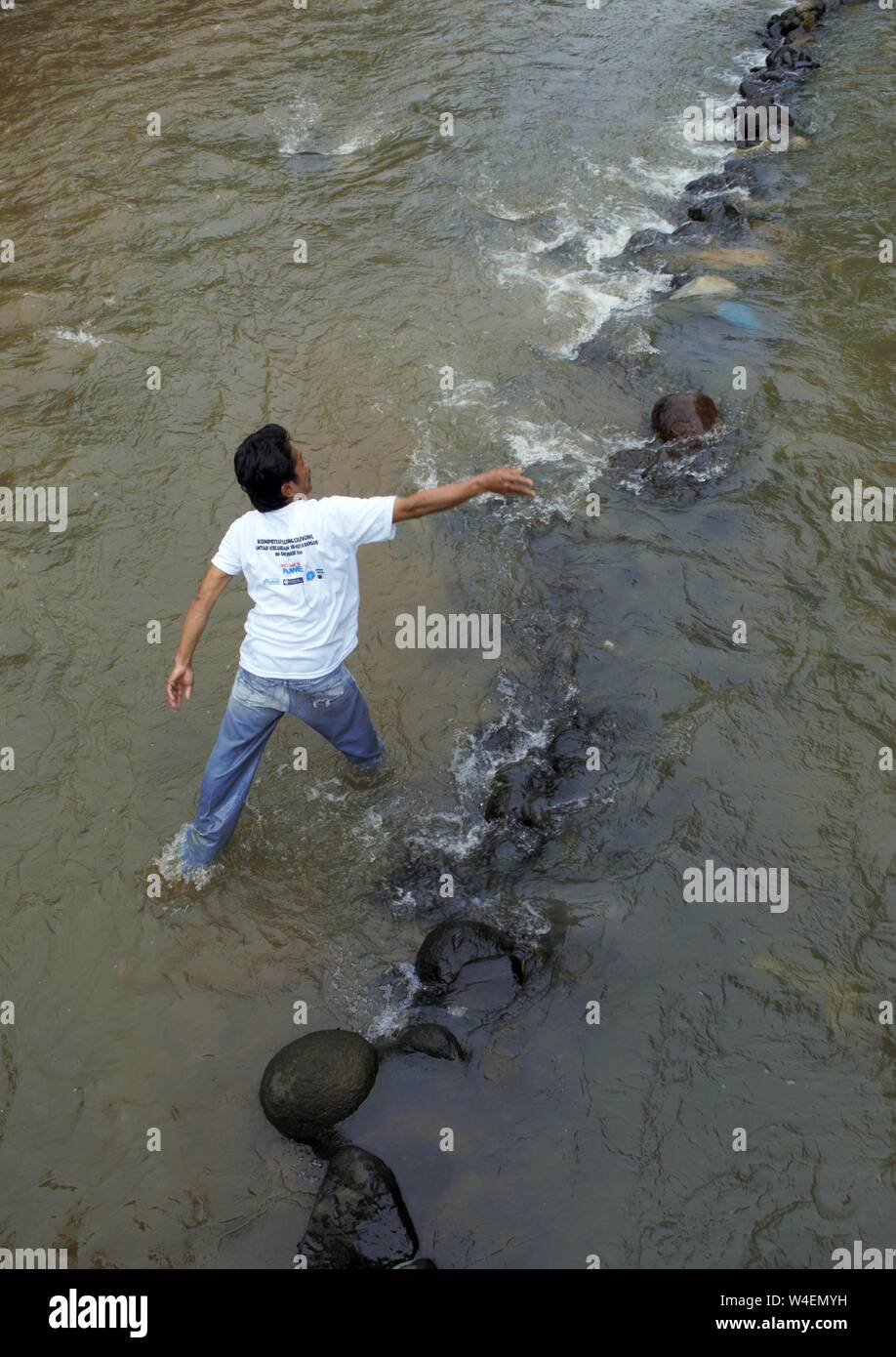 Bogor, West Java, Indonesia - Luglio 2019 : un uomo messo la pietra per la costruzione di una piccola diga nel fiume Ciliwung. Foto Stock Bogor, West Java, Indonesia - Luglio 2019 : un uomo messo la pietra per la costruzione di una piccola diga nel fiume Ciliwung. Foto Stock