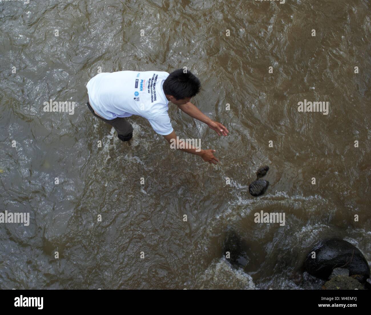 Bogor, West Java, Indonesia - Luglio 2019 : un uomo messo la pietra per la costruzione di una piccola diga nel fiume Ciliwung. Foto Stock Bogor, West Java, Indonesia - Luglio 2019 : un uomo messo la pietra per la costruzione di una piccola diga nel fiume Ciliwung. Foto Stock
