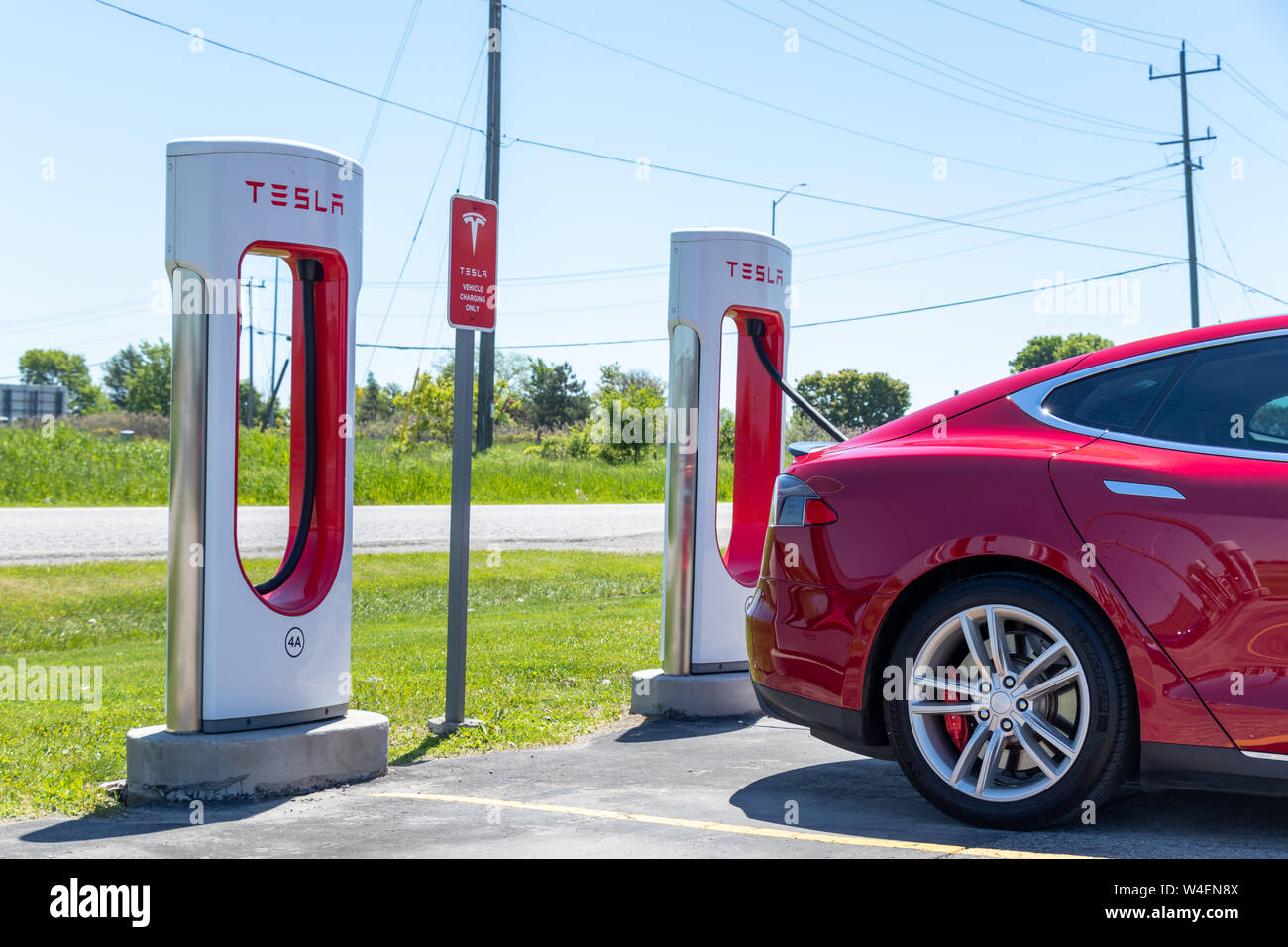 Rosso Modello Tesla S visto durante la carica a Tesla Supercharger stazione nel porto di speranza, Ontario. Foto Stock