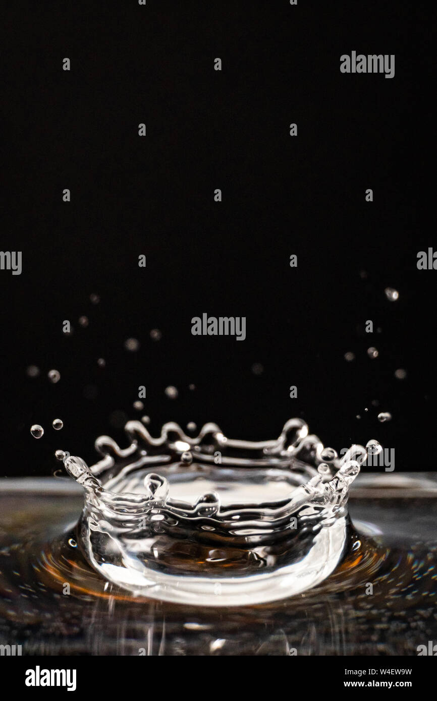 Goccia di acqua, trasparente goccia d'acqua, acqua splash close-up isolati su sfondo nero, un sacco di bolle, movimento di liquido Foto Stock