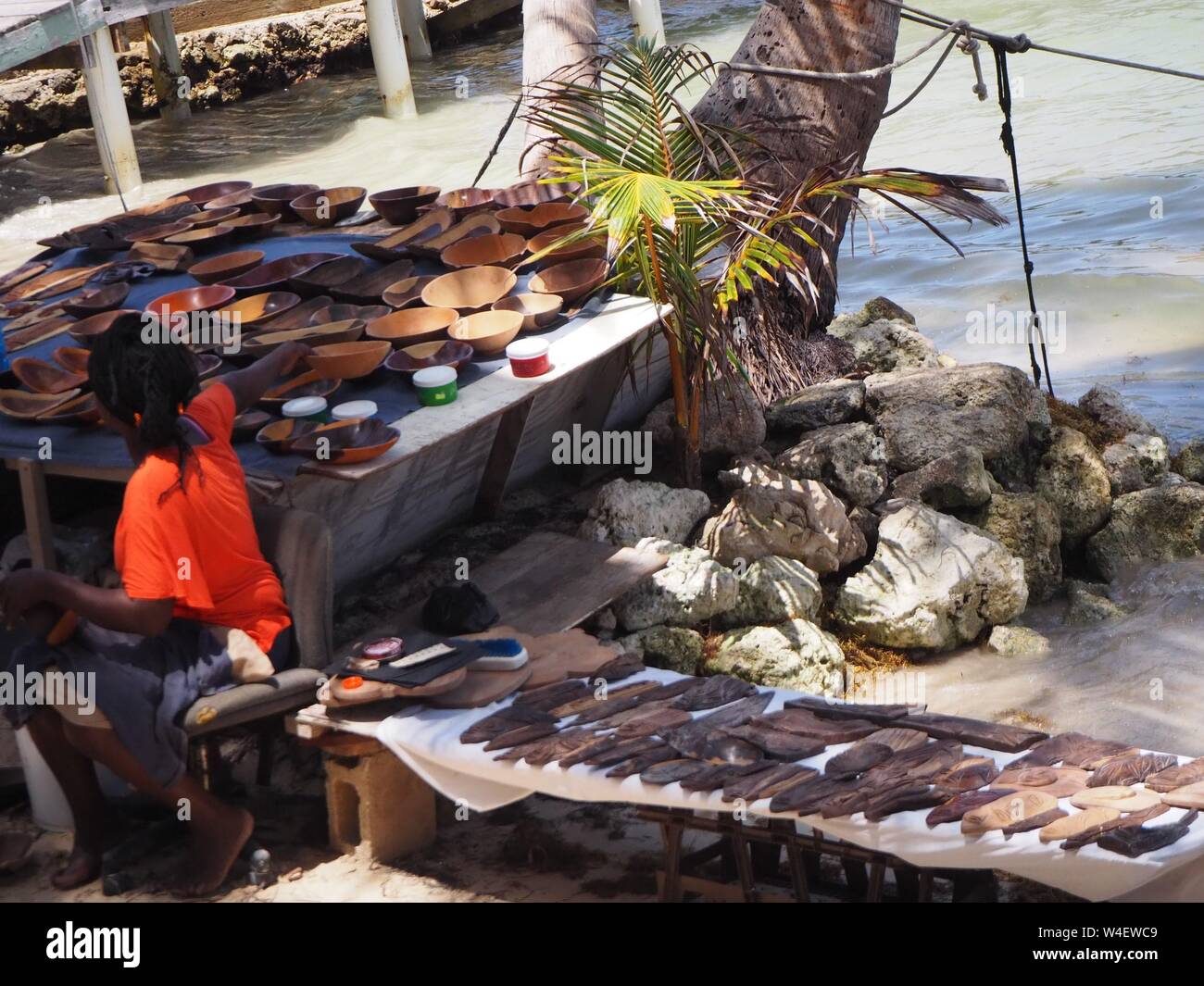 Artigianale di sculture in legno e il venditore sulla spiaggia di Ambergris Caye Belize, dei Caraibi. Tecnica di vendita sulla spiaggia. Negozio di souvenir per i turisti. Foto Stock