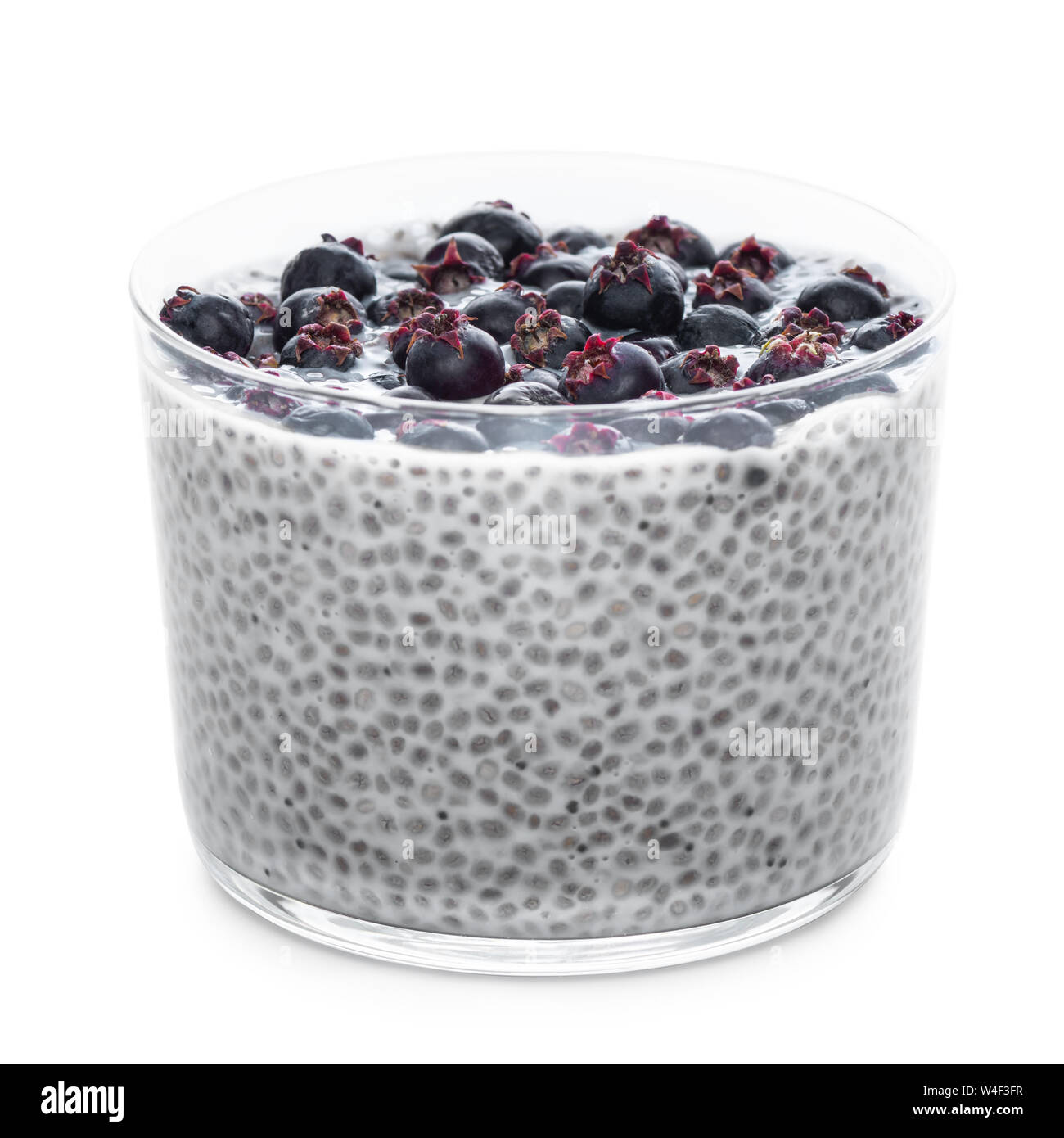 Semi di chia pudding con bacche di Saskatoon in vetro isolato su sfondo bianco, il concetto di dieta mangiare sano Foto Stock
