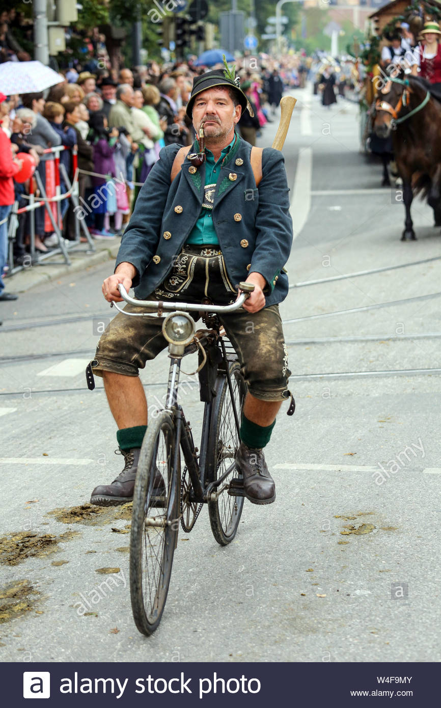 Un uomo in bavaresi tradizionali cicli di abbigliamento una vecchia moto durante l'Oktoberfest bavarese parade Foto Stock