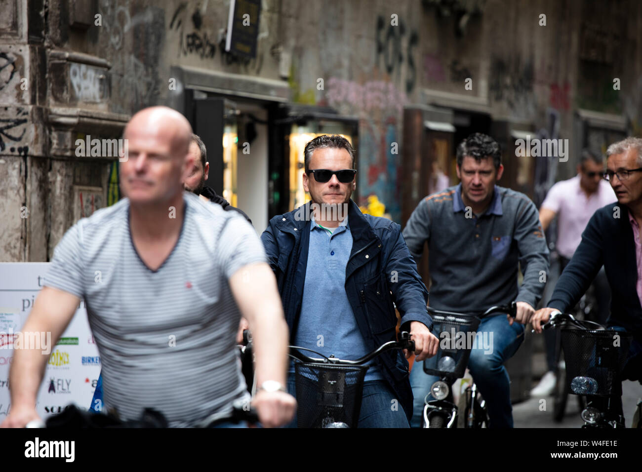 Un gruppo di uomini a cavallo, lungo una strada a una gita in bicicletta del centro storico di Napoli. Foto Stock