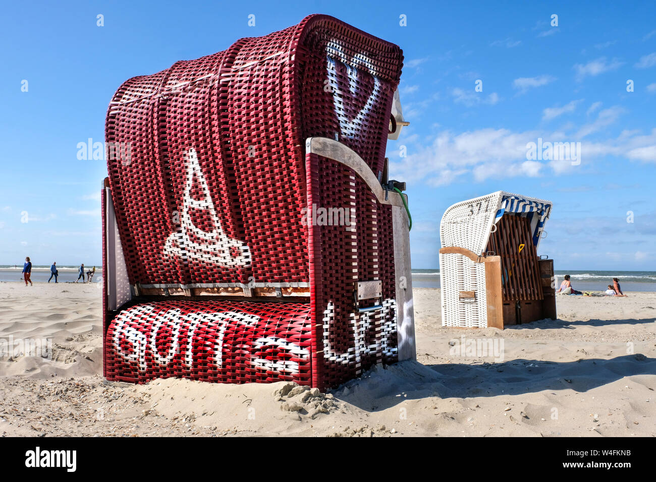 Sdraio sulla spiaggia con la scritta "DIO = l'amore". Chiesa ecumenica sdraio sulla spiaggia della evangelica e la Chiesa cattolica sta nella stagione estiva 2019 sulla spiaggia di Est isola Frisone Spiekeroog, Germania --- Strandkorb mit der Aufschrift "GOTT = Liebe". Ökumenischer Kirchen-Strandkorb der evangelischen und katholischen Kirche steht in der Sommersaison 2019 am Strand der ostfriesischen Insel Spiekeroog, Deutschland Foto Stock