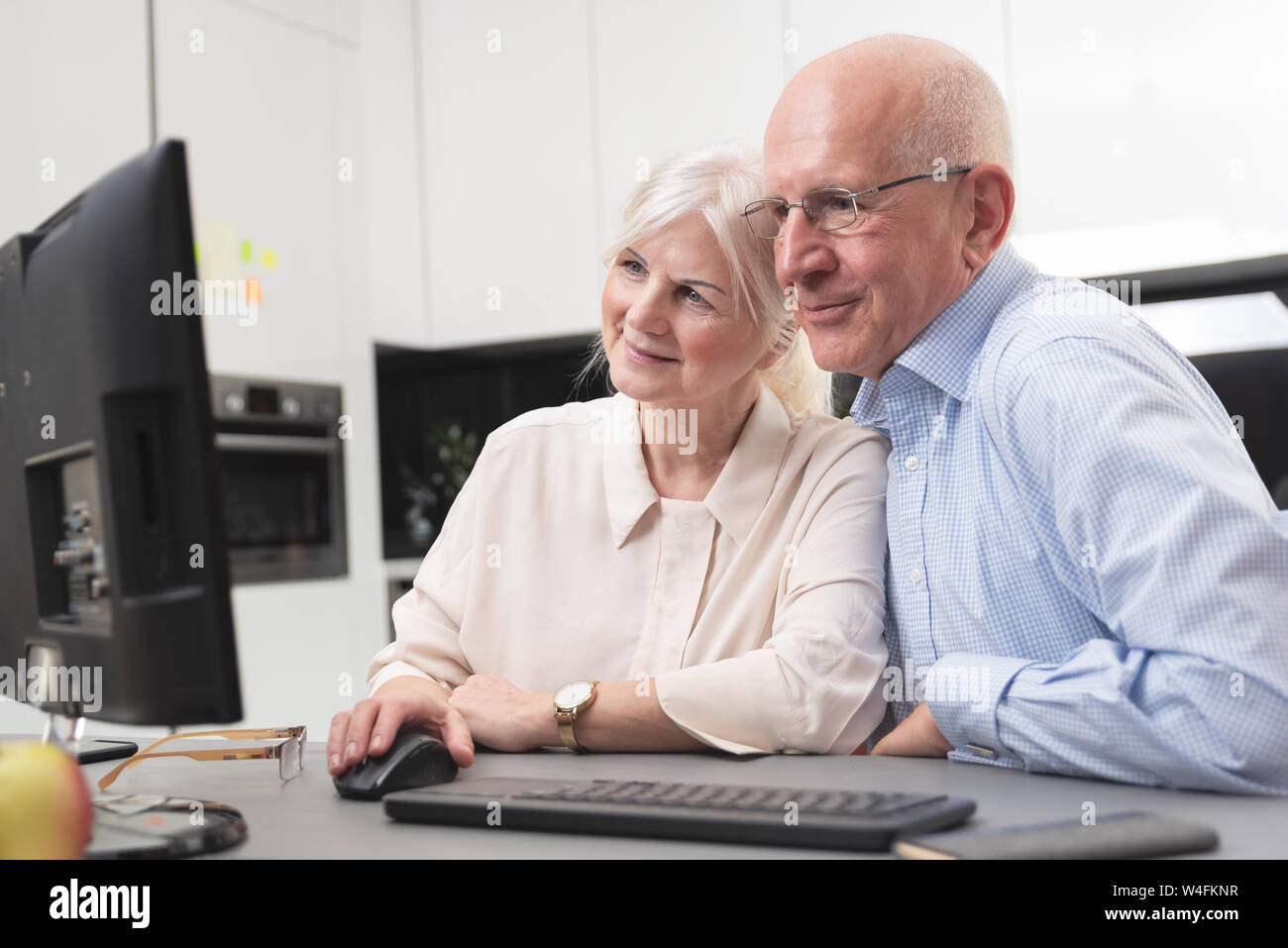Felice vecchio paio di godere insieme al computer. Gli anziani utilizzano un computer, essi guardare le foto che hanno ricevuto. Foto Stock