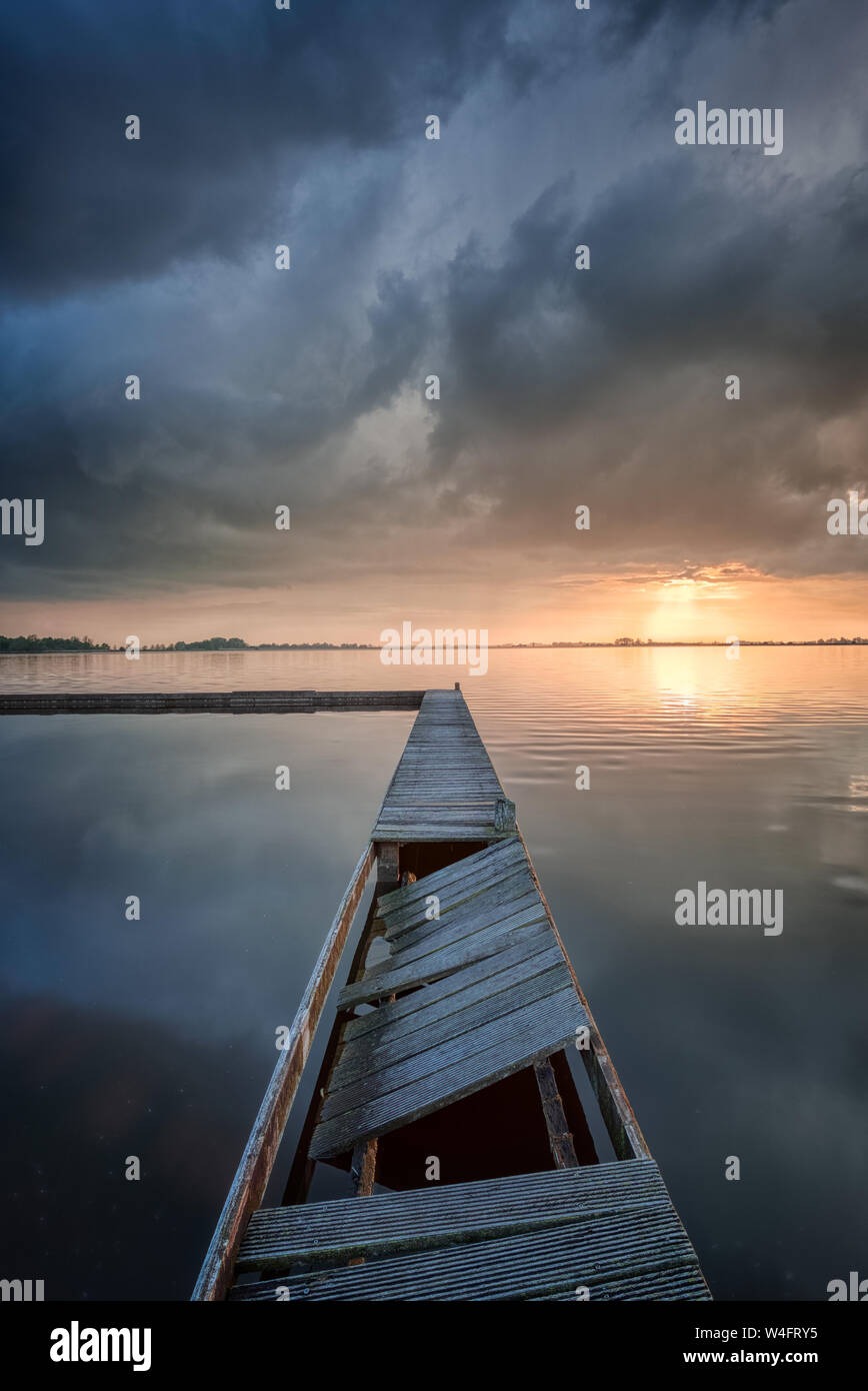Un paesaggio marino paesaggio di un lago con un pontile e bellissimi riflessi di nubi sull'acqua - Schildmeer, Paesi Bassi Foto Stock Un paesaggio marino paesaggio di un lago con un pontile e bellissimi riflessi di nubi sull'acqua - Schildmeer, Paesi Bassi Foto Stock