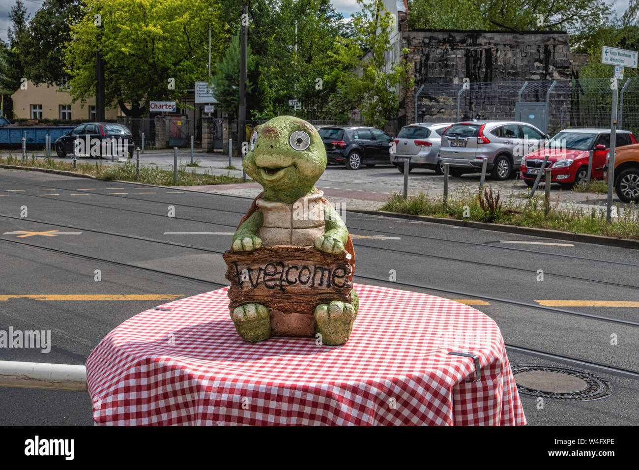 Ornamento di rana tenendo premuto segno di benvenuto sul tavolo esterno Villa Toscana ristorante italiano in Alt-Schmöckwitz,Berlino, Germania Foto Stock