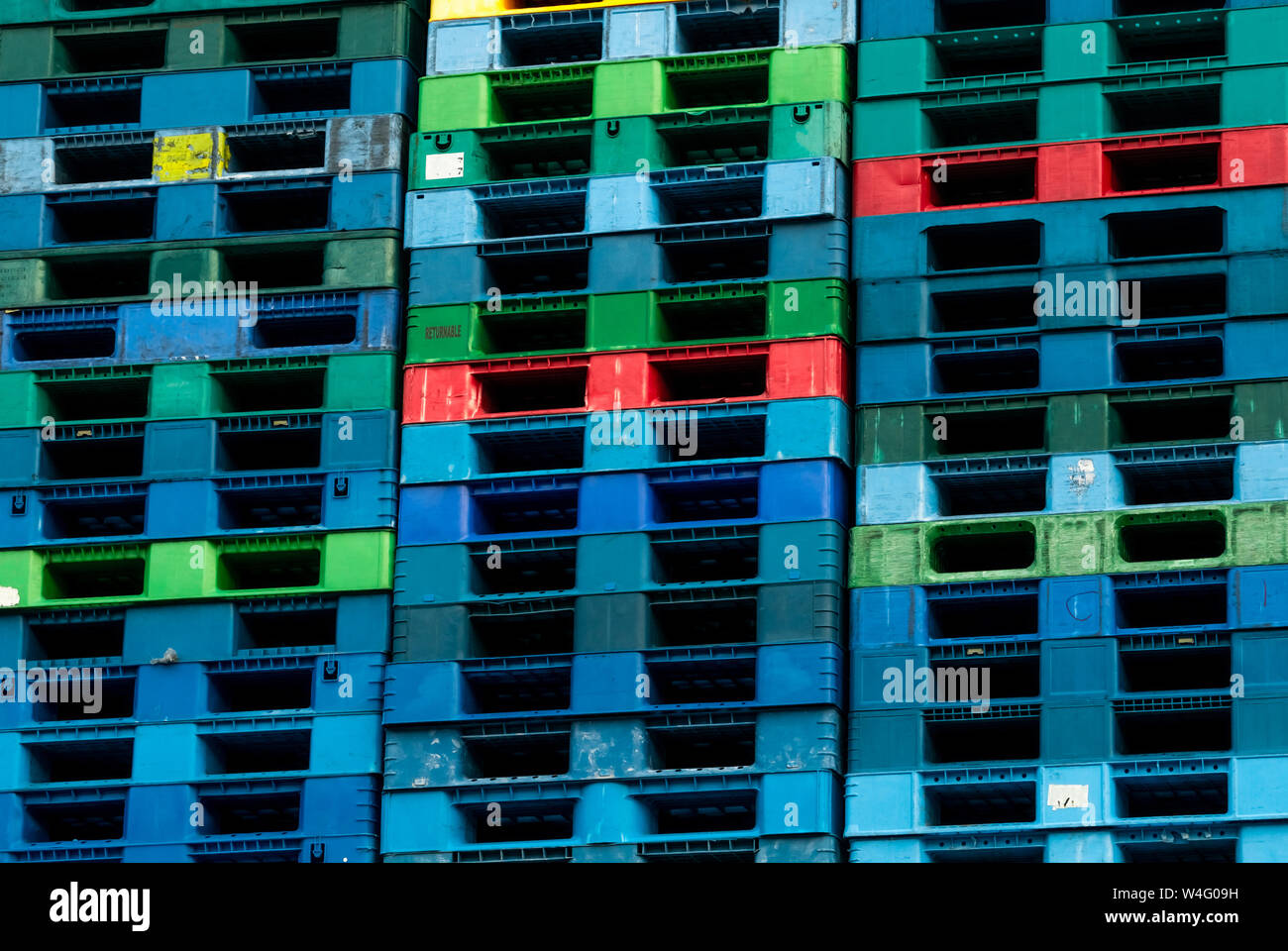 Plastica pallet di spedizione in vendita e in affitto business. L'industria plastica pallet impilati in fabbrica a magazzino. Carico e Spedizione il concetto di business. Foto Stock